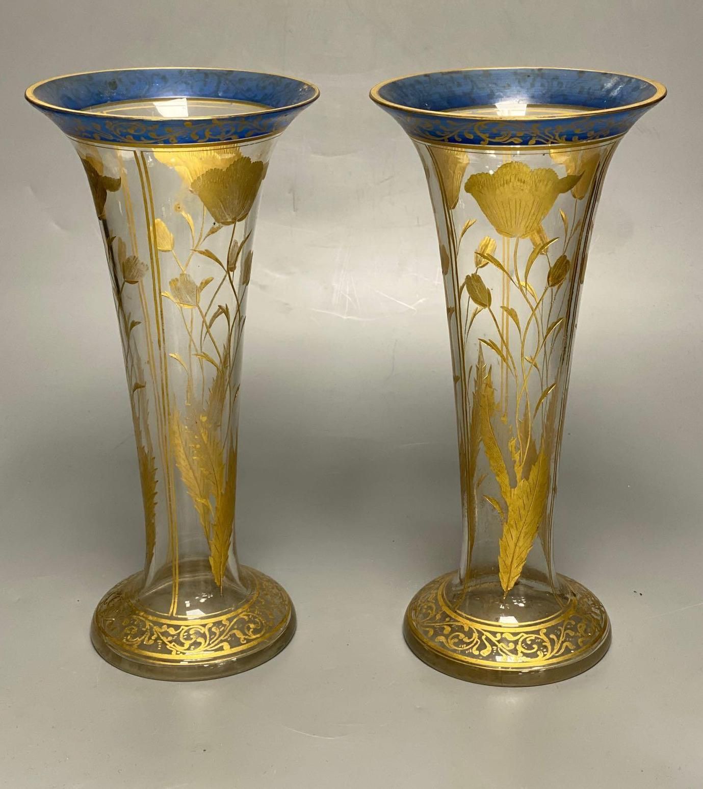 A pair of Bohemian gilt painted and blue flash cut trumpet shaped glass vases, 26cm